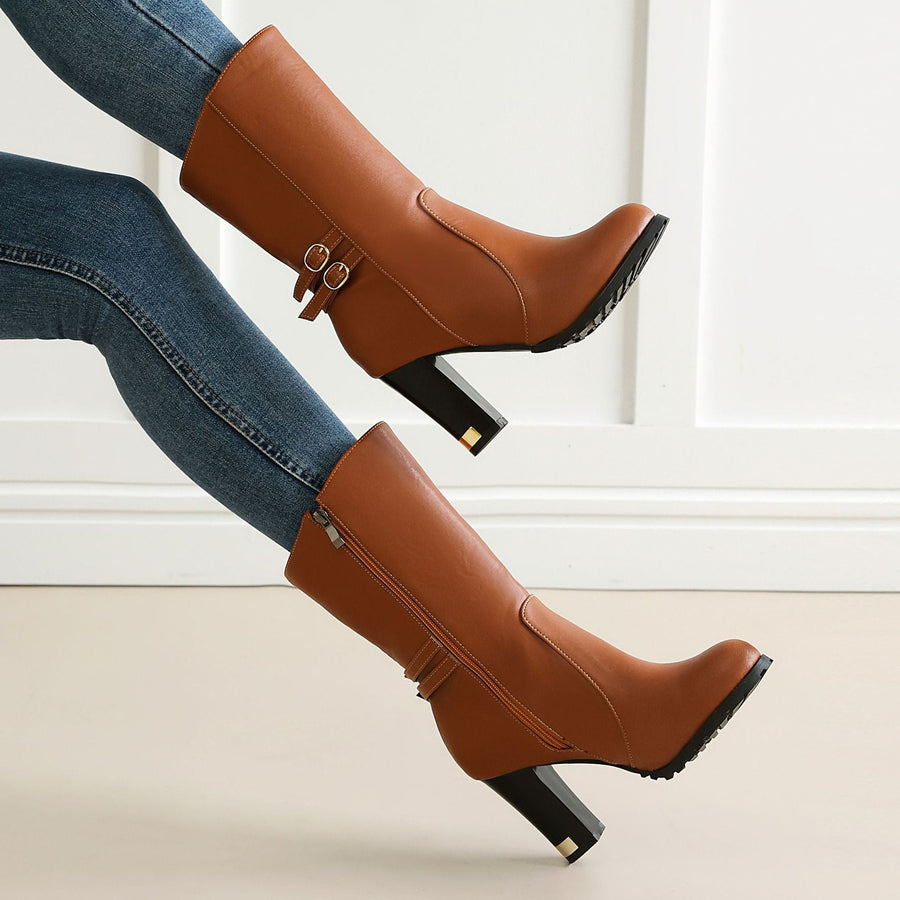 Tan brown faux leather knee-high boots featuring block heels, side zippers, and double strap buckles.