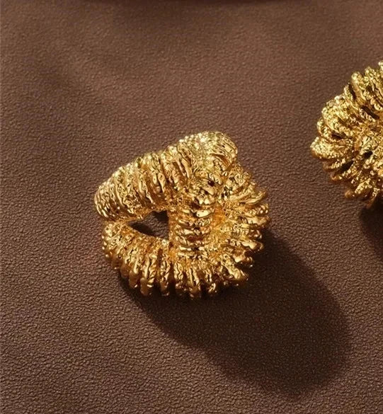 Gold textured metal ring, chunky abstract knotted style with a rough, crinkled surface.