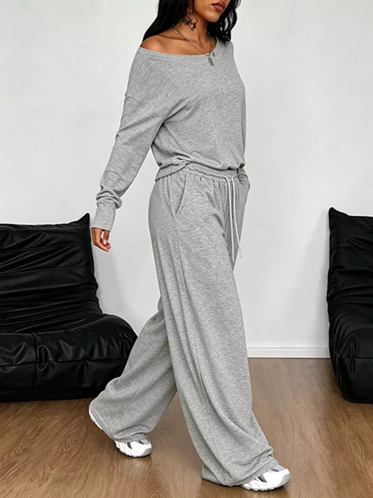 Plus size one-shoulder top and drawstring pants set from Trendsi, featuring a stylish matching outfit for curvy figures.