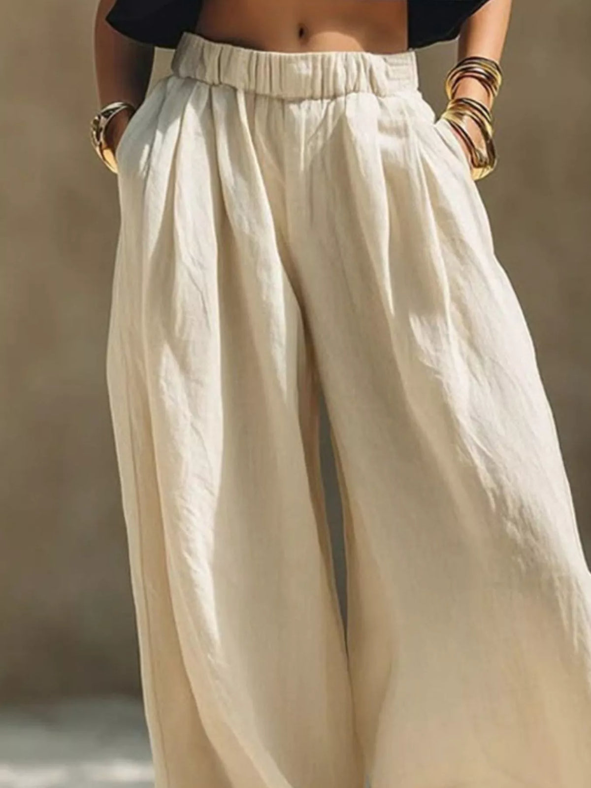 Plus size wide-leg pants with full elastic waistband from Trendsi, shown in a relaxed fit style with flowing fabric.