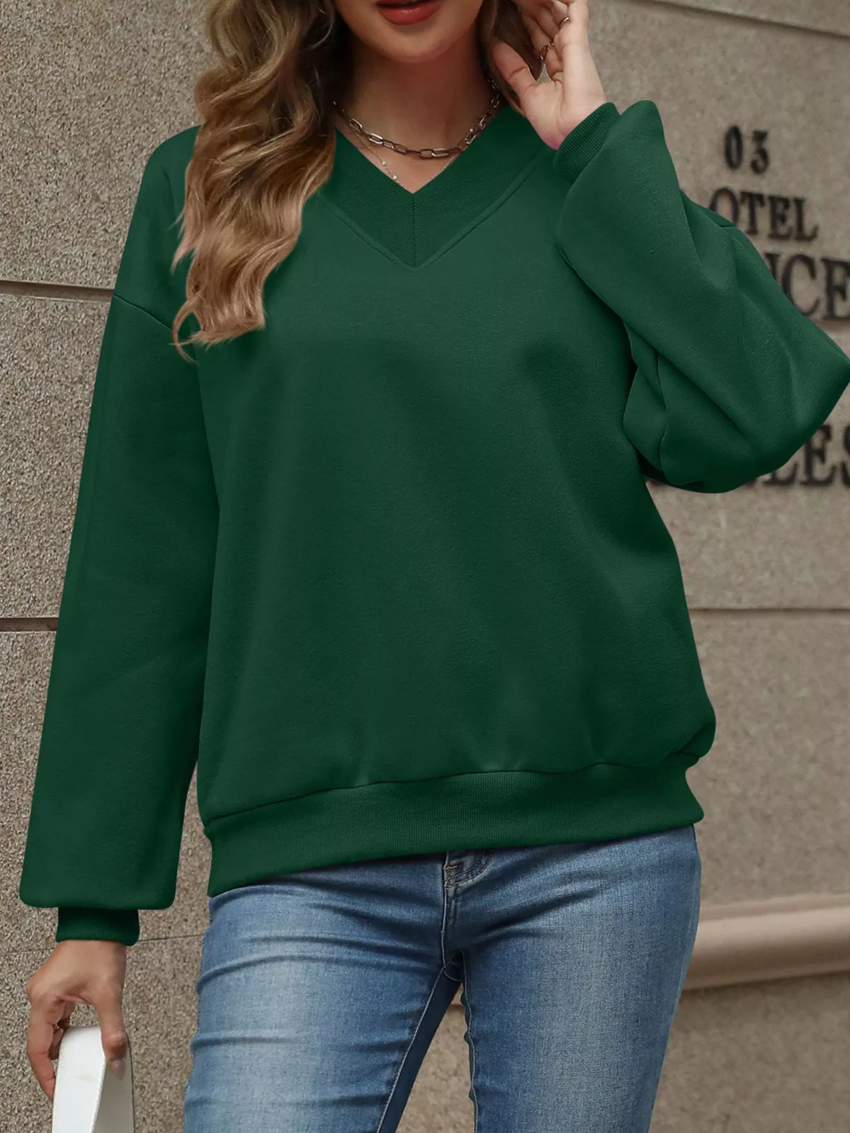 V-neck solid color casual sweatshirt by Trendsi, featuring a relaxed fit and soft fabric, shown in a neutral color.