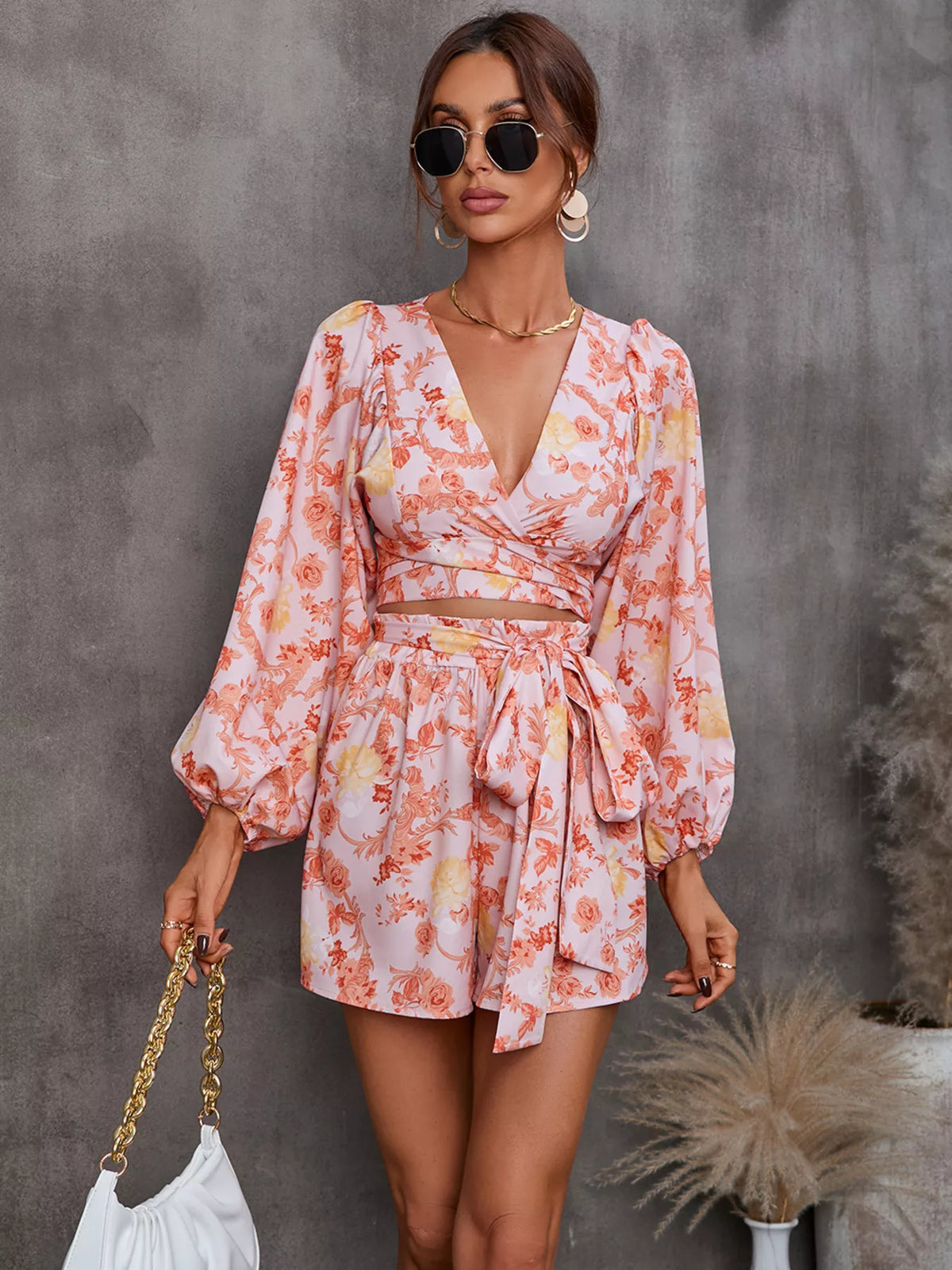 Printed long sleeve romper with cutout front, stylish jumpsuit by Plush Fashion Hub, featuring a modern design and comfortable fit.