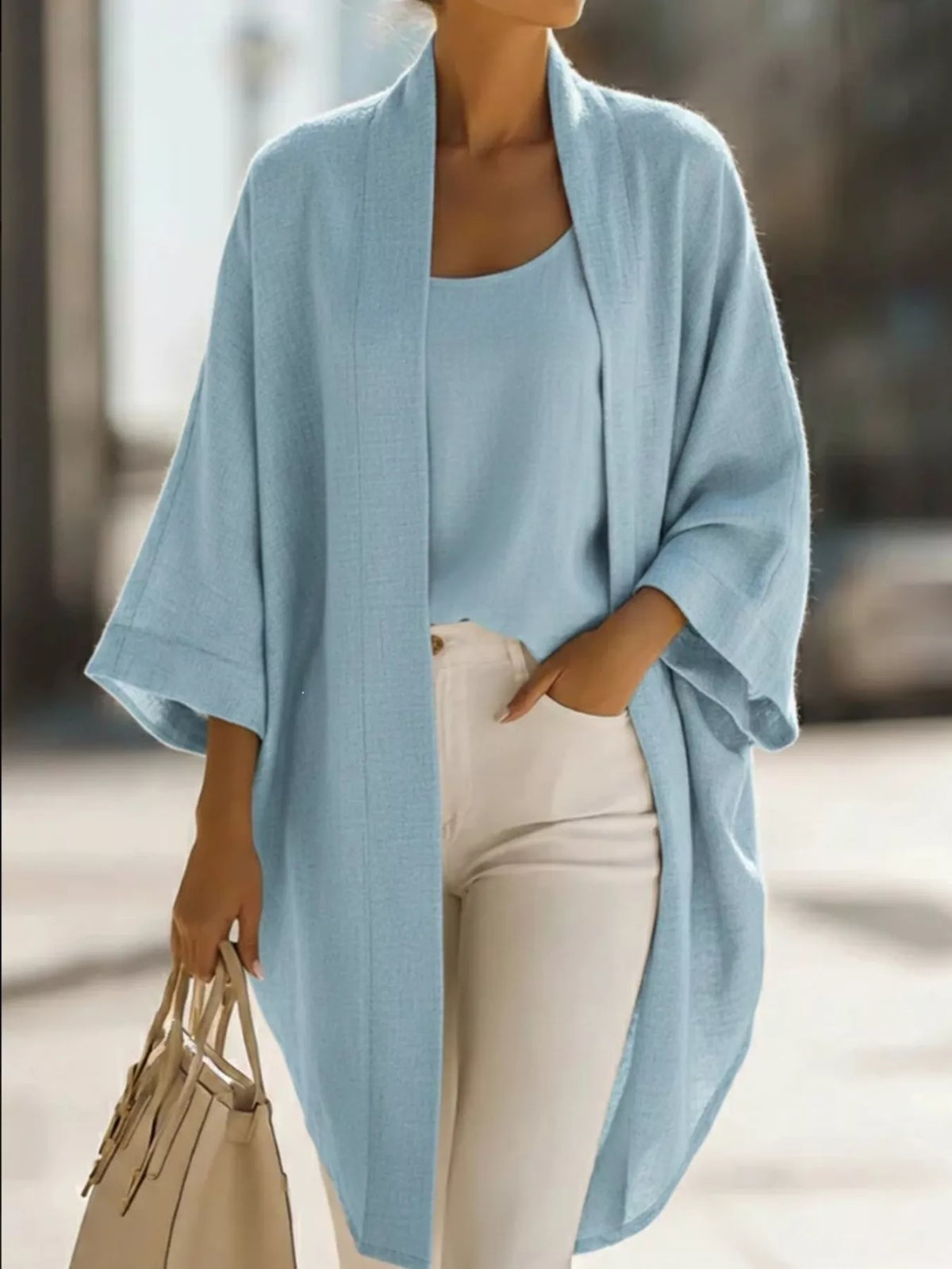 Plus size open-front cardigan and matching tank top set by Trendsi, featuring a cozy, stylish cardigan with a relaxed fit.