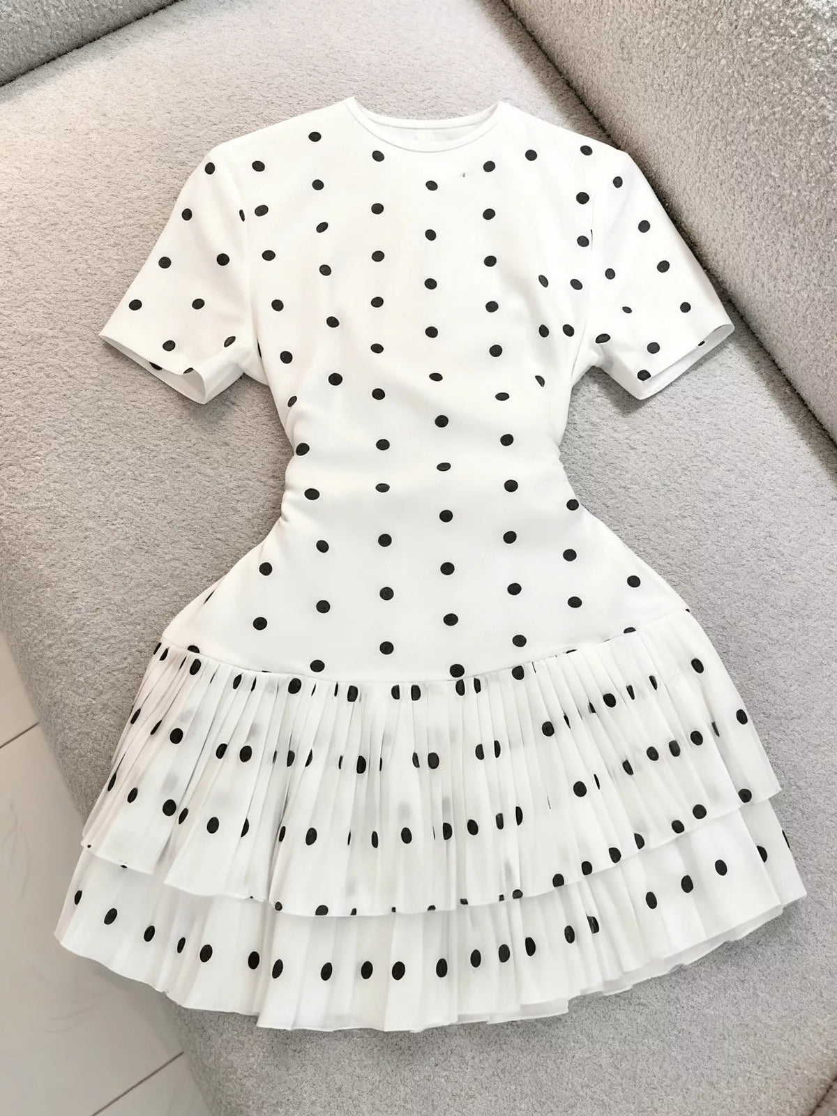 Polka dot pleated hem mini dress by Trendsi featuring a stylish design with a flowy silhouette and trendy pattern.