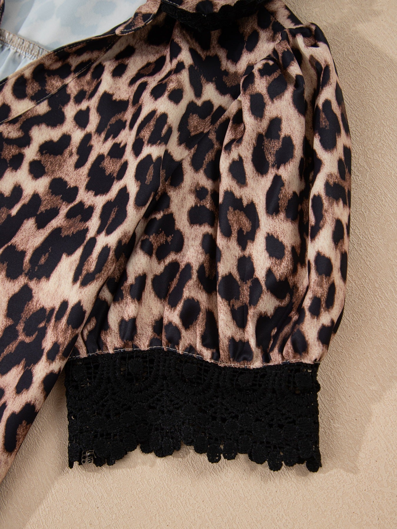 Leopard print short sleeve blouse from Trendsi with lace trim, button front, and relaxed fit, displayed on a hanger.