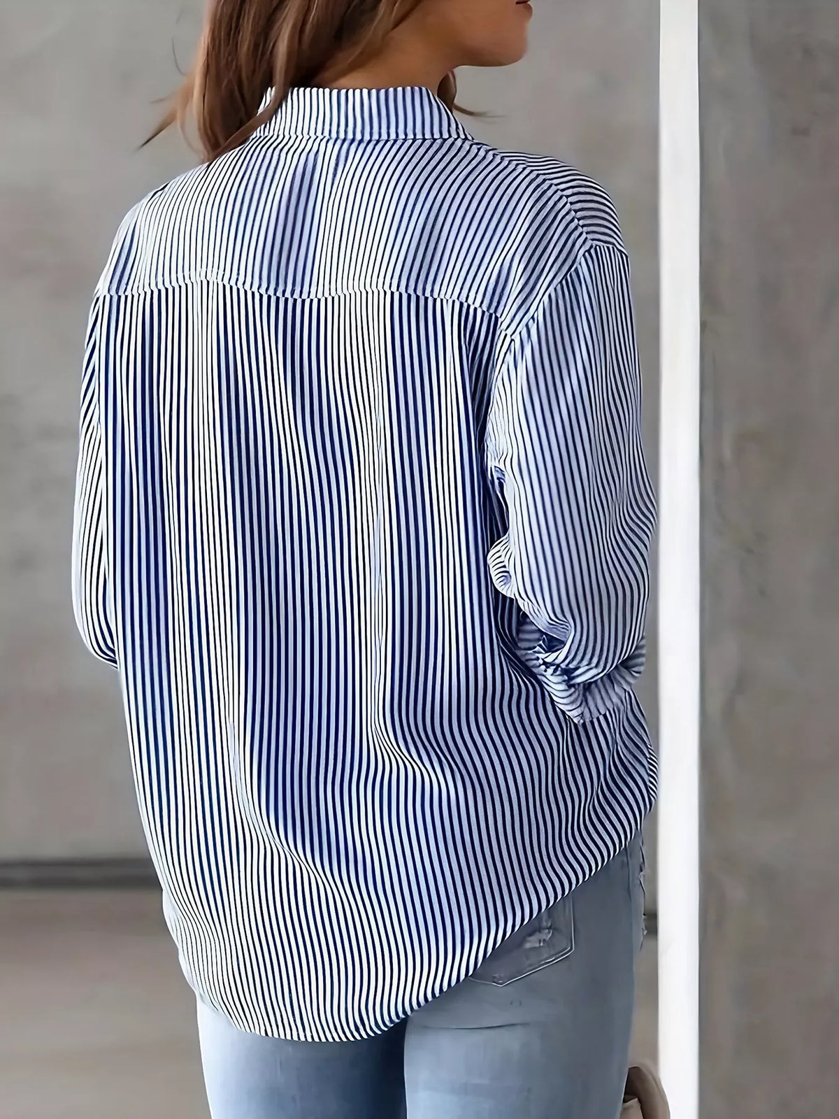 Women’s classic striped button-down shirt by Trendsi, featuring a casual fit with vertical stripes and a collar.