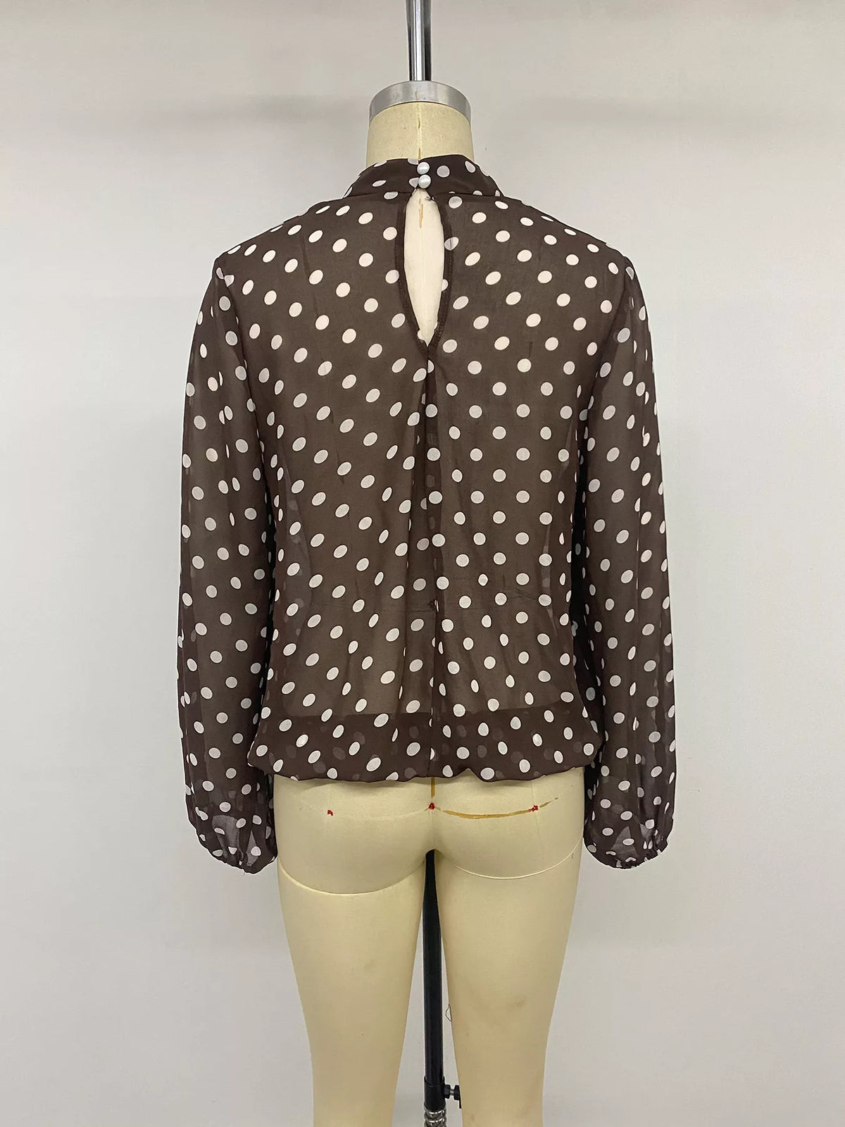 Polka dot mock neck long sleeve blouse by Trendsi, featuring a stylish design with a fitted silhouette and classic pattern.