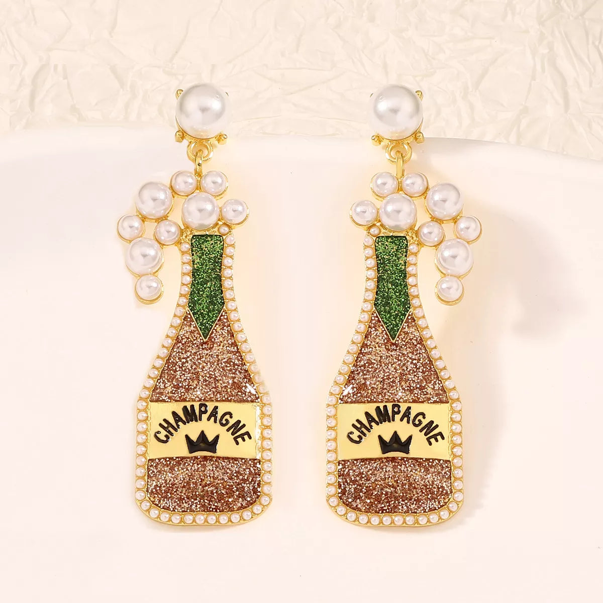 Champagne bottle earrings with pearl accents from Plush Fashion Hub, featuring gold-tone metal and playful jewelry design.