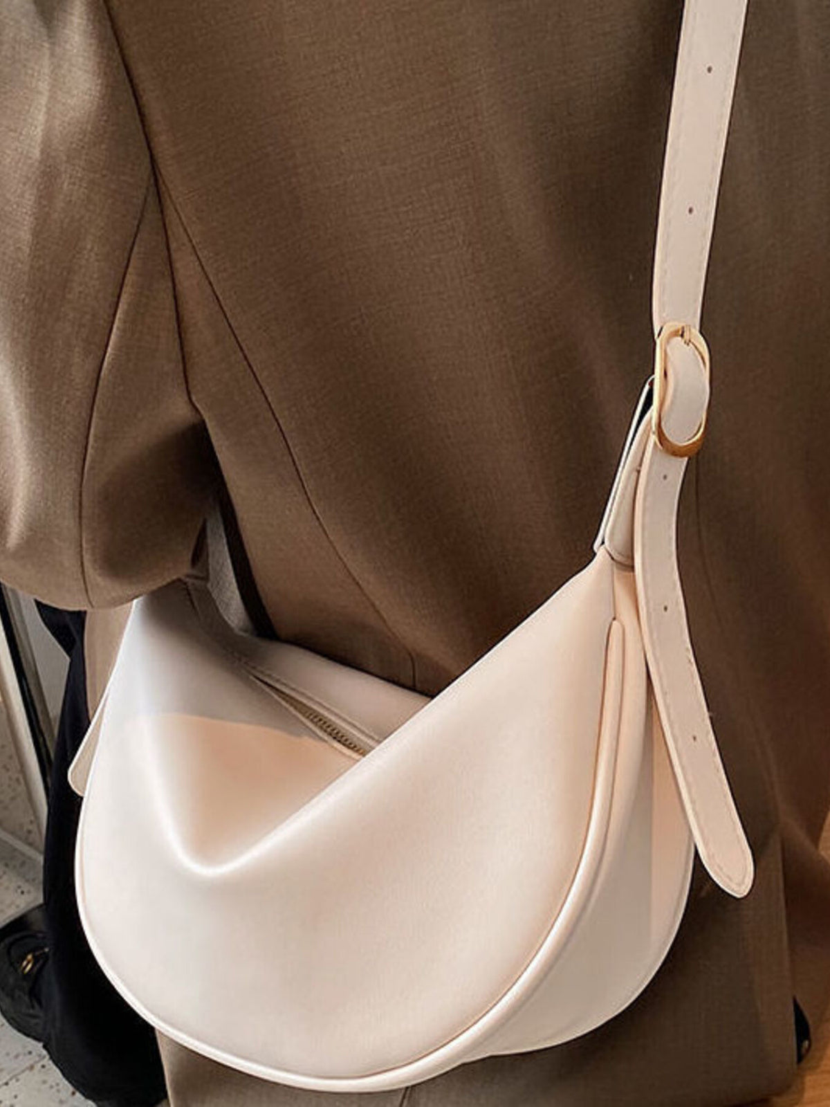 Minimalist crescent crossbody bag in smooth PU leather by Plush Fashion Hub, showing its sleek curved design and adjustable strap.