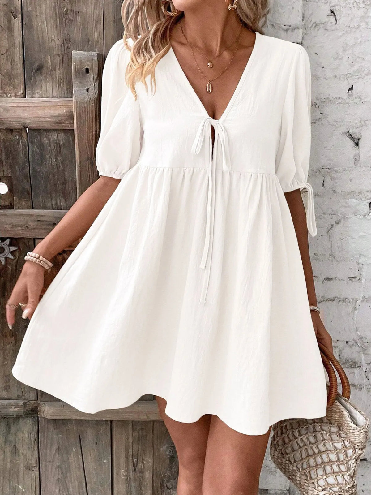 Cotton V-neck tie-front mini dress with puff sleeves by Plush Fashion Hub, featuring a fitted silhouette and stylish design.