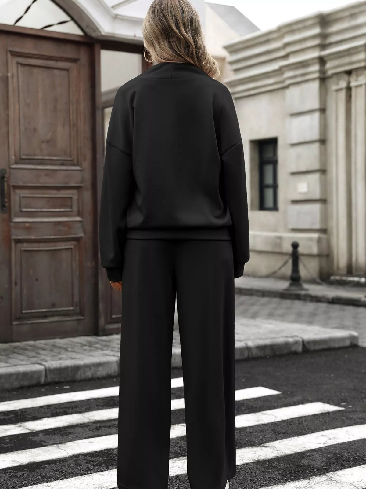 Women’s half zip sweatshirt and wide-leg pants set by Trendsi, featuring a cozy top and flowing trousers on a model.