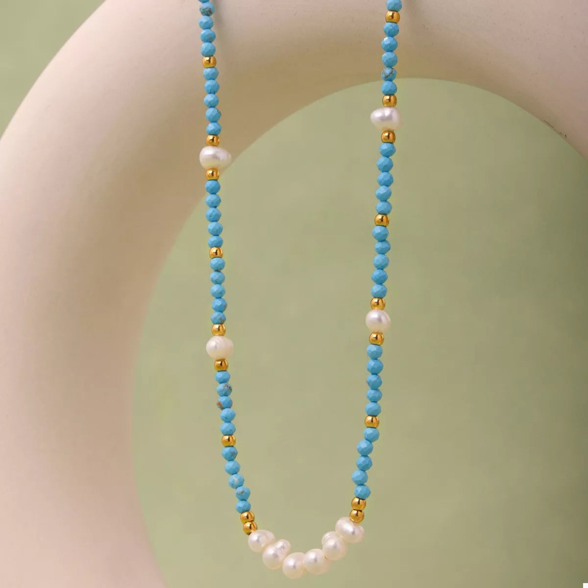 Turquoise pearl beaded necklace featuring a string of glossy turquoise pearls on a plush fashion hub necklace.
