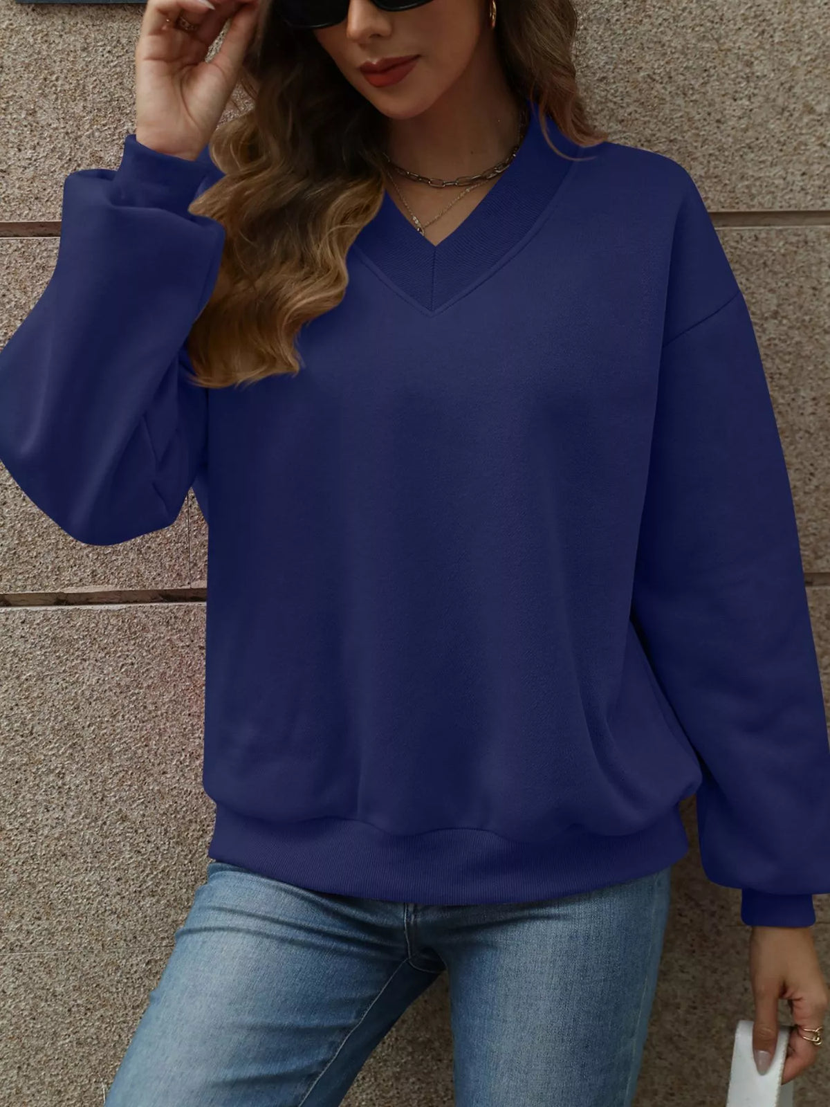V-neck solid color casual sweatshirt by Trendsi featuring a relaxed fit and long sleeves, ideal for everyday comfort.