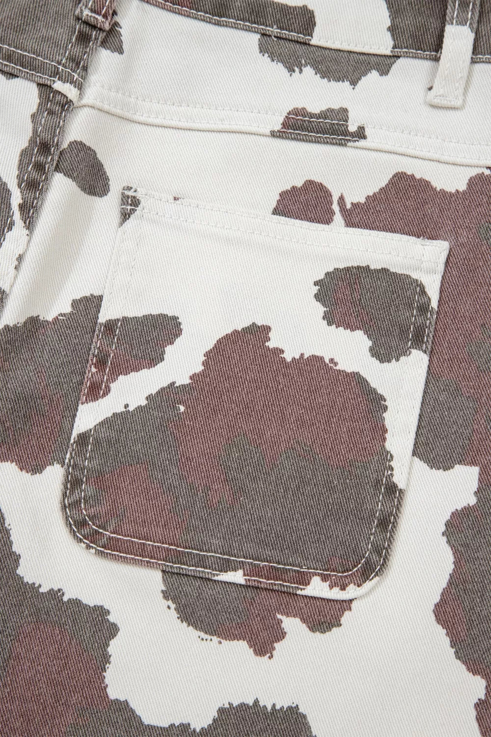 Cow spots printed Plush Fashion Hub jeans with multiple pockets, featuring a stylish and playful design for casual wear.