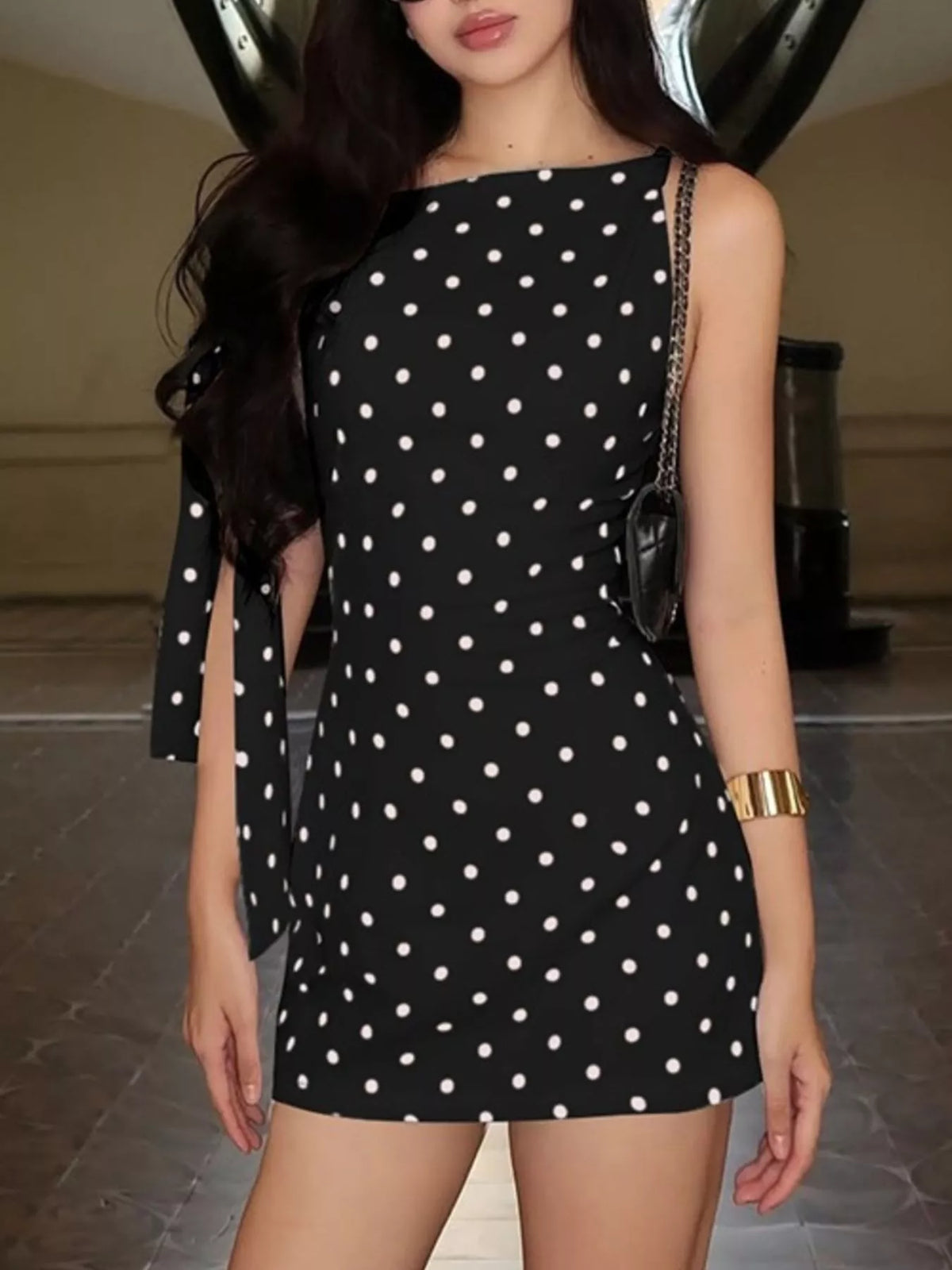 Polka dot sleeveless mini dress with bow accents by Plush Fashion Hub, featuring a playful pattern and stylish design.