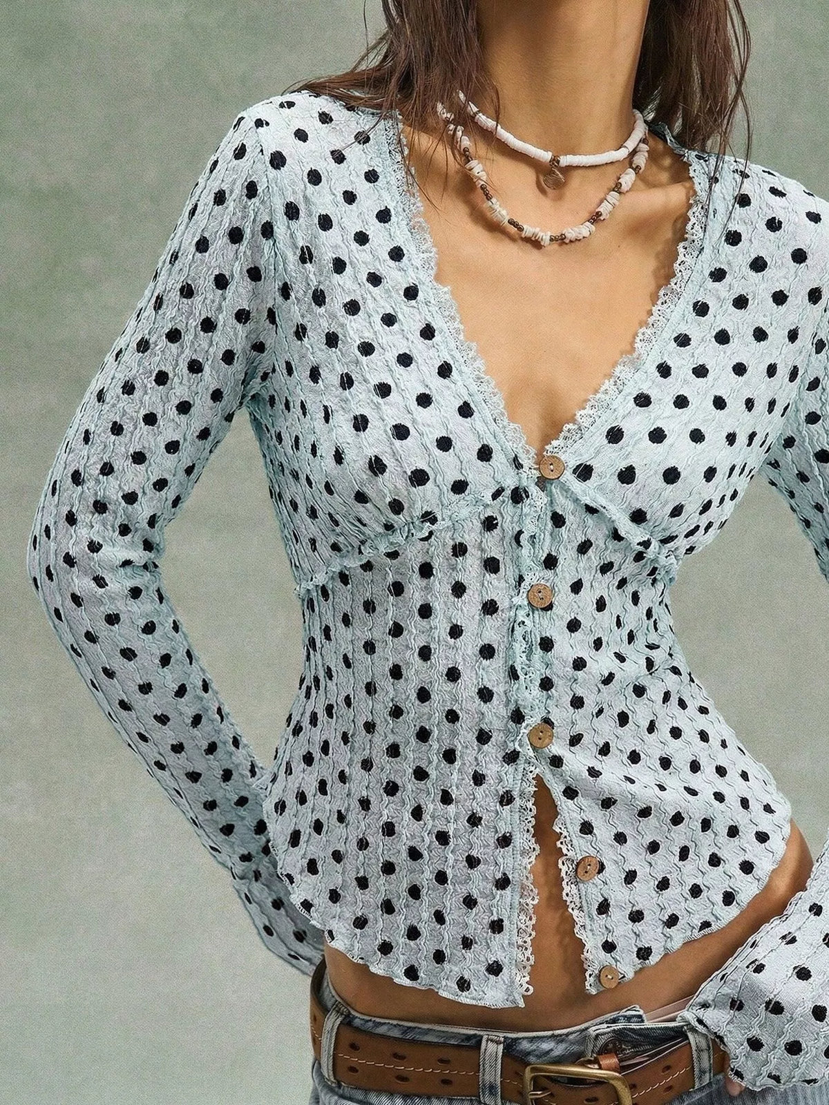 Women’s long sleeve textured blouse with polka dot pattern, button-down style by Trendsi, shown in a stylish, casual setting.