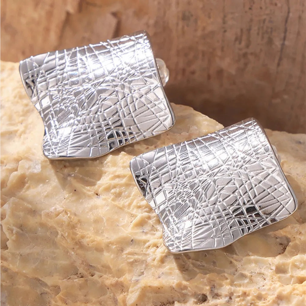 Textured titanium steel stud earrings from Plush Fashion Hub, close-up view showing the sleek, modern design and metallic finish.