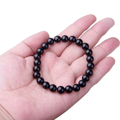 Black Onyx Bracelet with 8MM geometric black agate beads on elastic cord in hand.