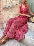 Elegant tiered halter neck maxi dress by Trendsi featuring flowing fabric and a stylish design perfect for summer events.