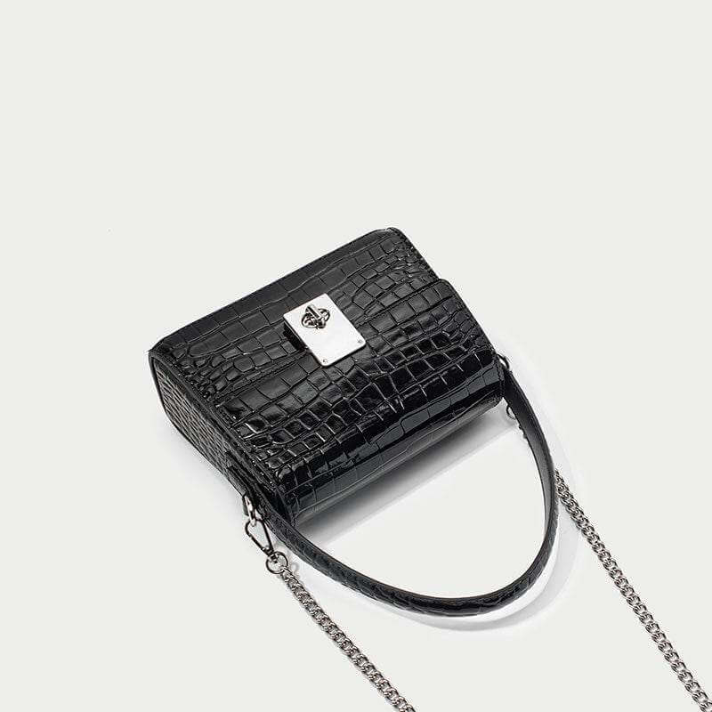 New leather handbag in trapezoid shape with chain strap and crocodile pattern.