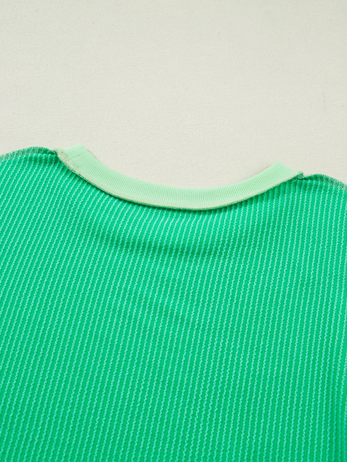 Women’s ribbed short sleeve T-shirt with twist hem and contrast stitching by Plush Fashion Hub, showcasing a fitted casual top.
