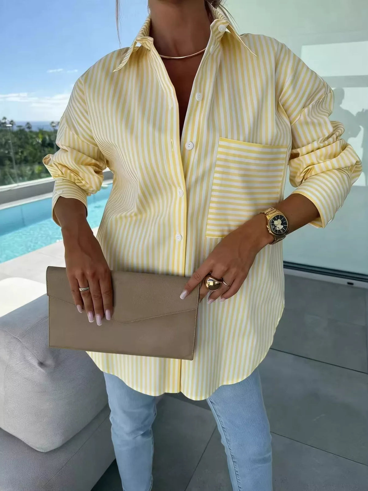 Women's long sleeve striped button-up shirt by Trendsi, featuring a classic design with vertical stripes and a collar.