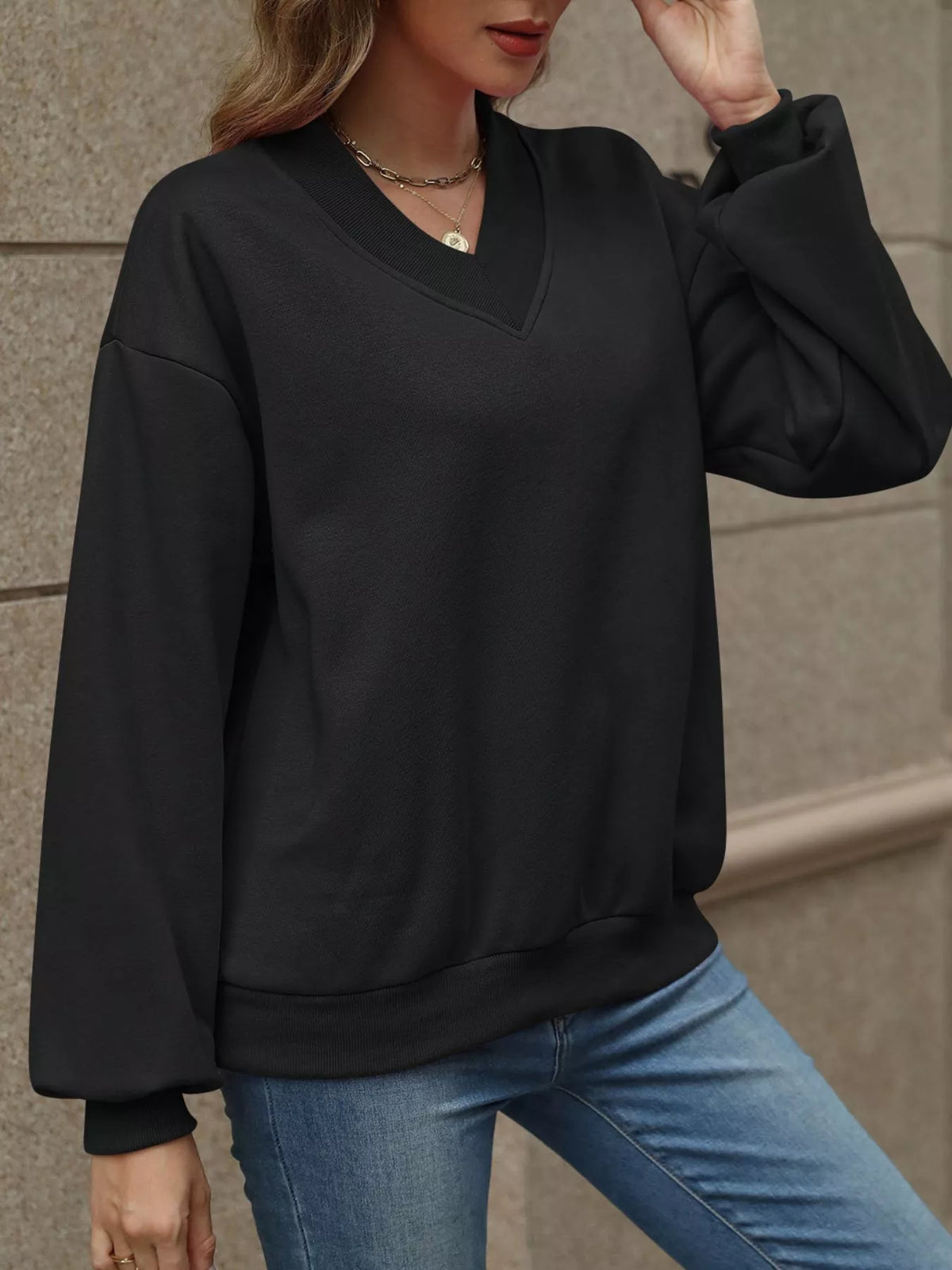 V-neck solid color casual sweatshirt from Trendsi, featuring a relaxed fit and soft fabric, displayed on a hanger.