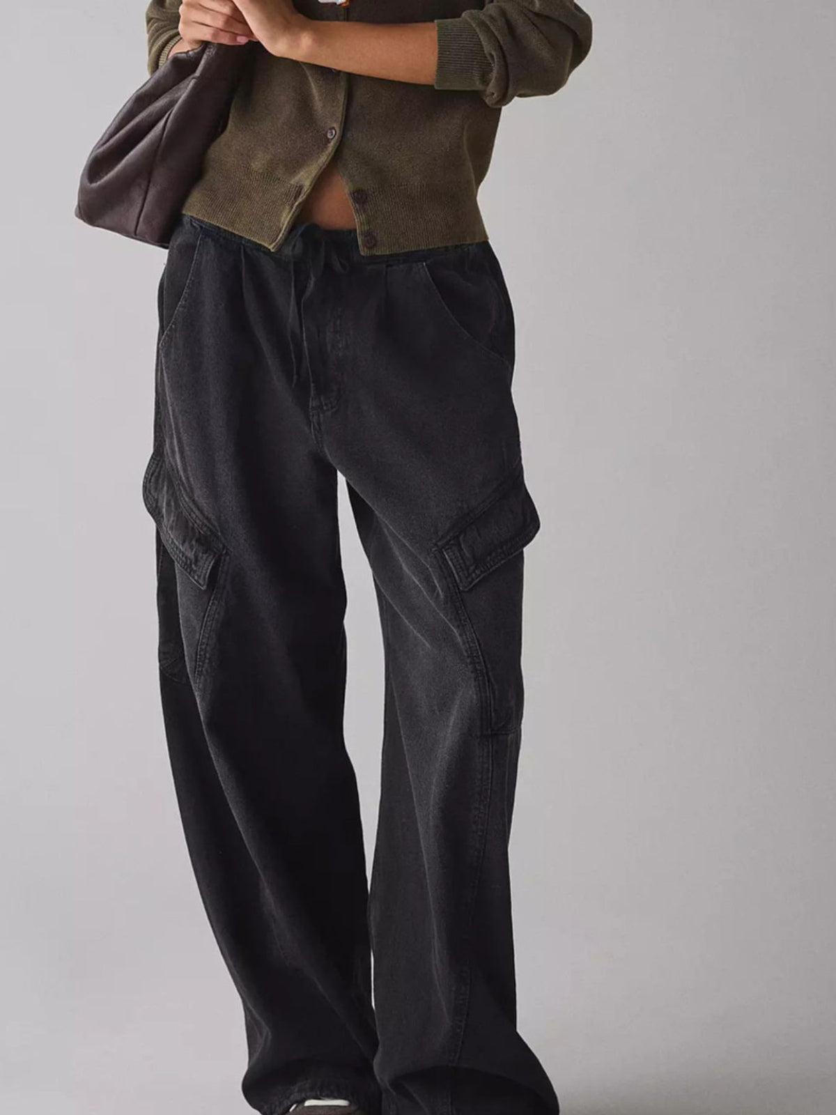 Women's relaxed fit utility denim cargo jeans with drawstring waist, shown in a casual pose featuring front pockets and belt loops.