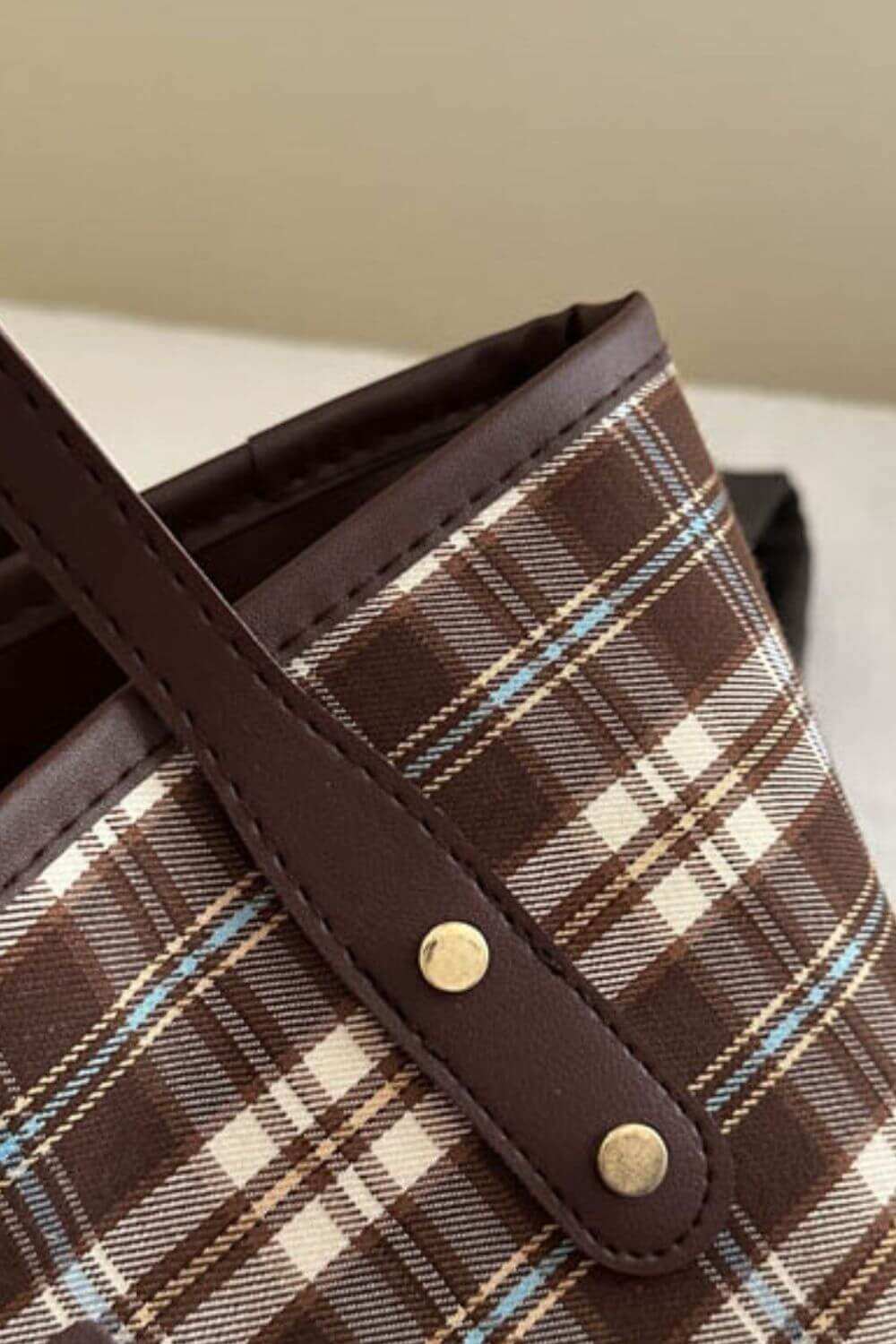 Plaid leather tote bag with chic design and spacious interior.