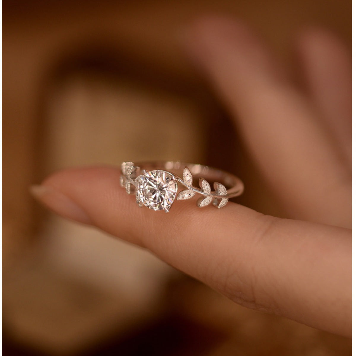 Sterling silver leaf ring with 1 carat moissanite gemstone, elegant jewelry piece from Plush Fashion Hub.
