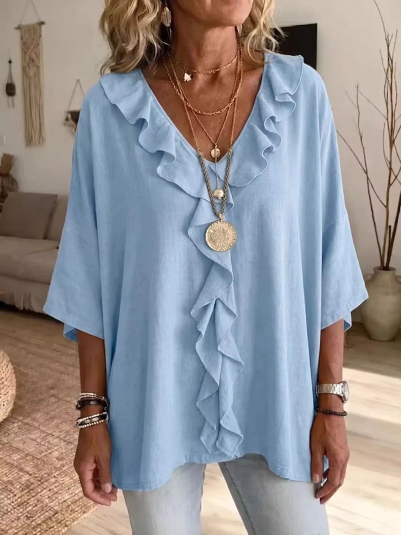 Plus size ruffle v-neck blouse with 3/4 sleeves by Trendsi, featuring a stylish design and feminine ruffle details.