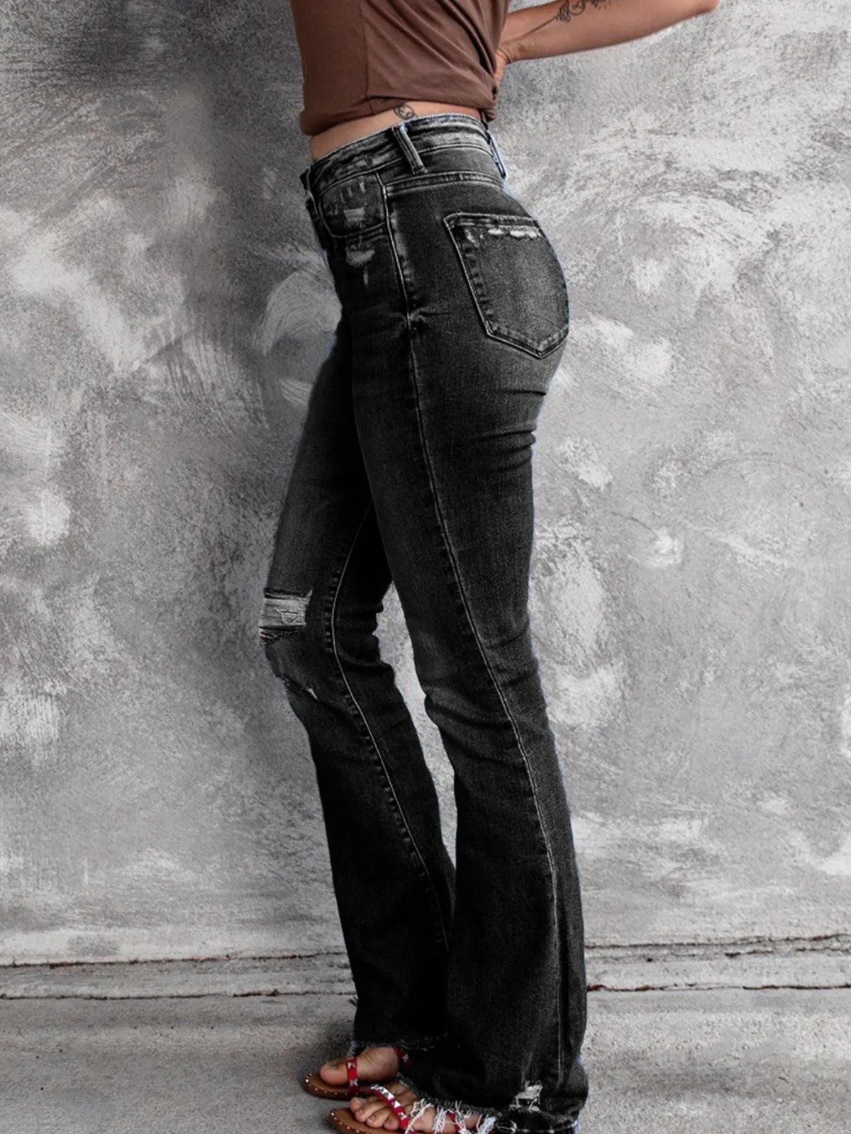 Distressed flare denim jeans by Plush Fashion Hub featuring ripped details and a high-waisted fit on a model.