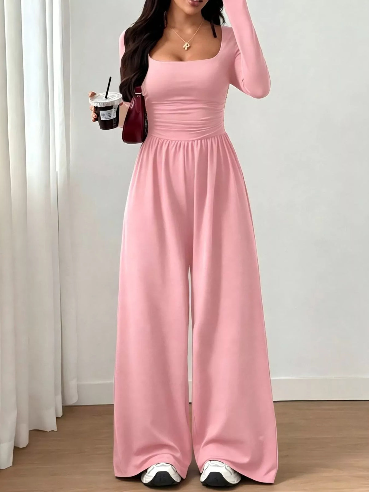 Ruched square neck wide-leg jumpsuit by Trendsi featuring a stylish design and flowing silhouette, displayed on a hanger.