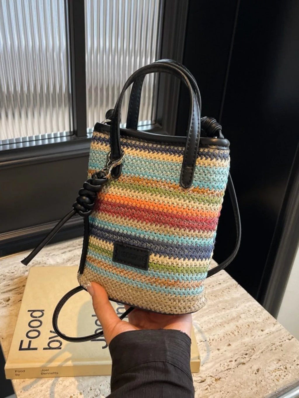 Striped woven mini crossbody bag with adjustable strap, featuring colorful horizontal stripes for trendy casual wear.