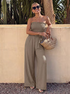 Strapped smocked strapless wide-leg jumpsuit from Trendsi, featuring a fitted bodice and flowing wide-leg pants.