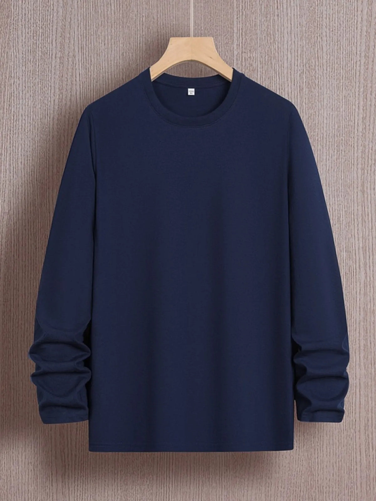 Plus size men's round neck long sleeve T-shirt by Trendsi, soft fabric, black color, close-up of the shirt's neckline and sleeve.