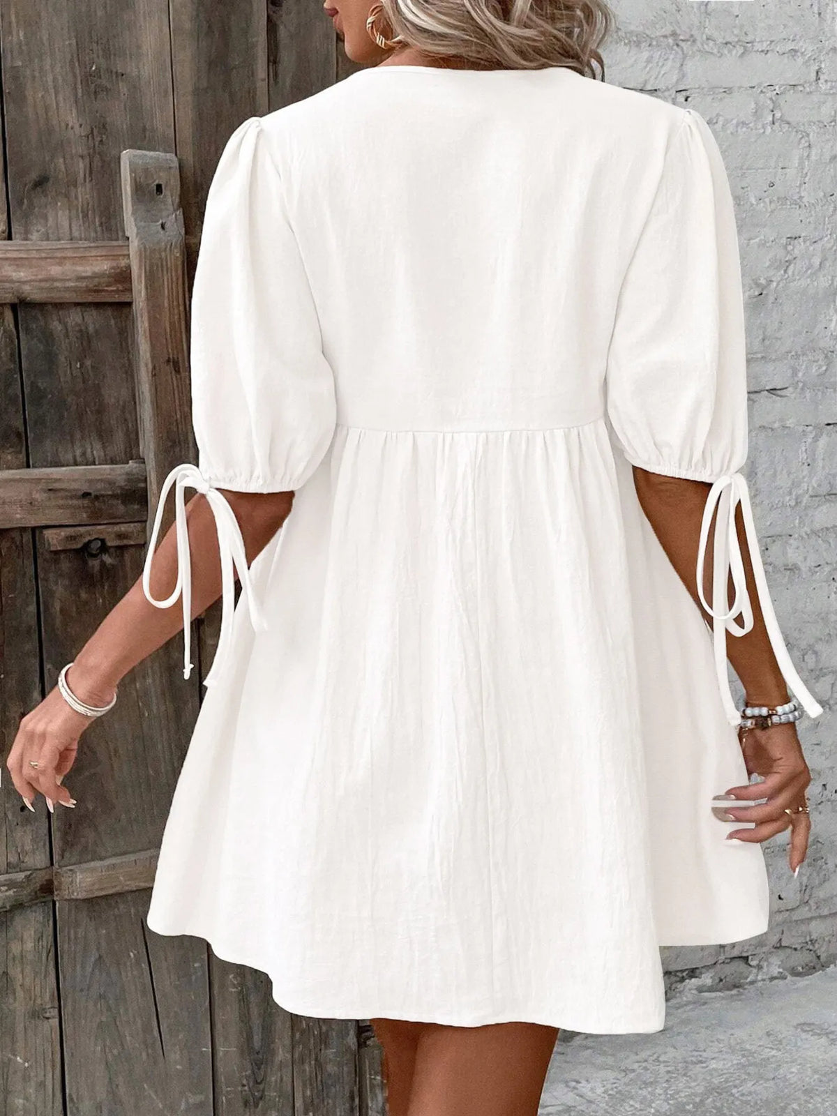 Cotton v-neck tie-front mini dress with puff sleeves by Plush Fashion Hub, featuring a stylish and comfortable design.