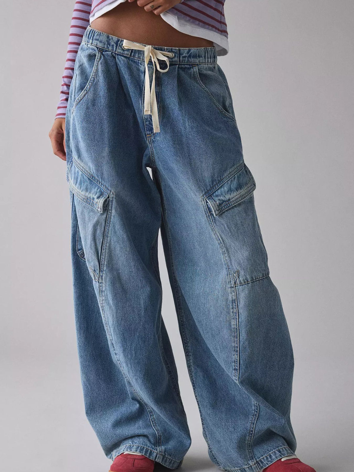 Women's relaxed fit utility denim cargo jeans with drawstring waist, styled with pockets and a casual look by Plush Fashion Hub.
