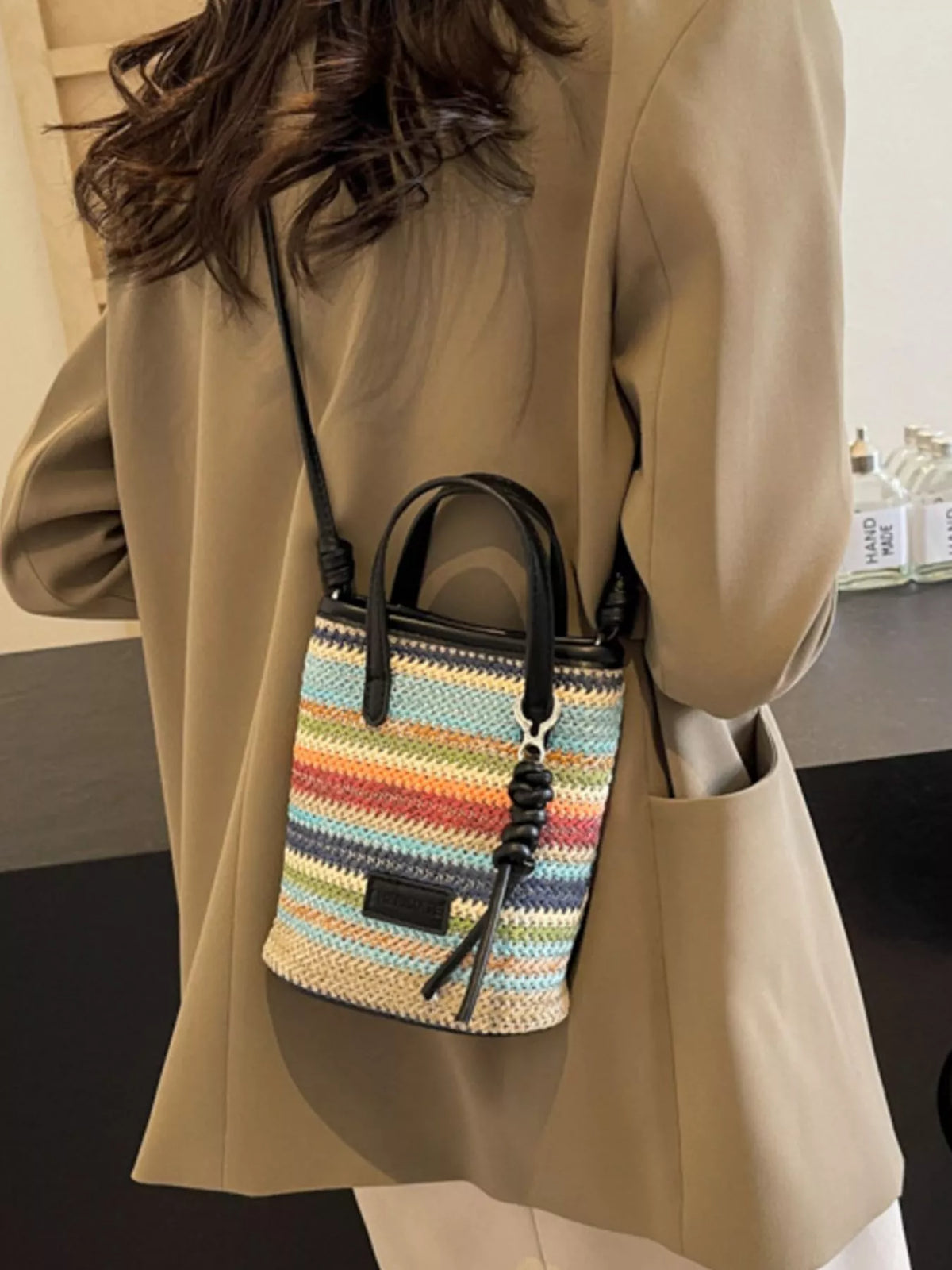 Striped woven mini crossbody bag from Plush Fashion Hub showing adjustable strap and colorful striped design.
