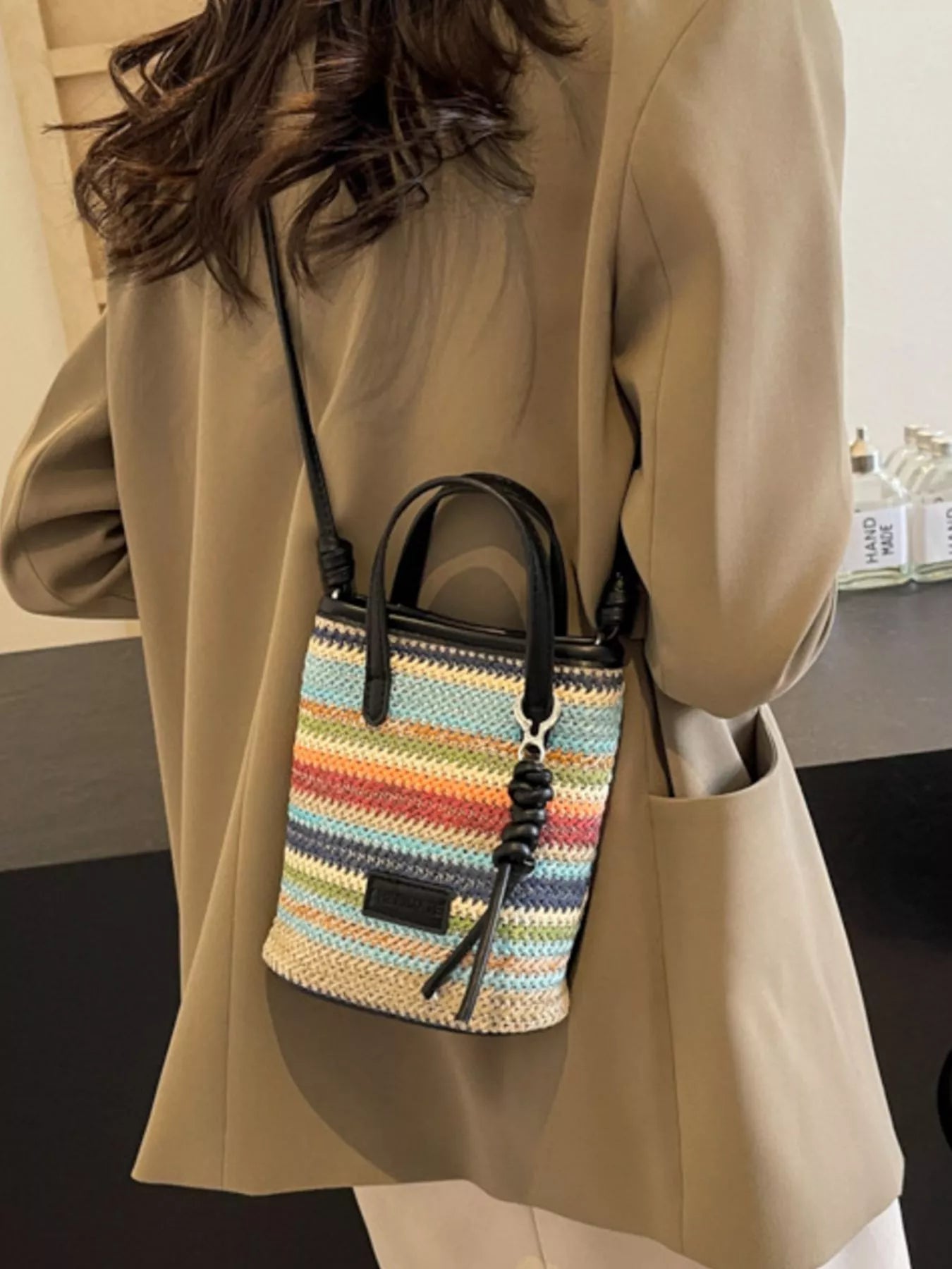 Striped woven mini crossbody bag by Trendsi, featuring a compact design with adjustable strap and colorful woven pattern.