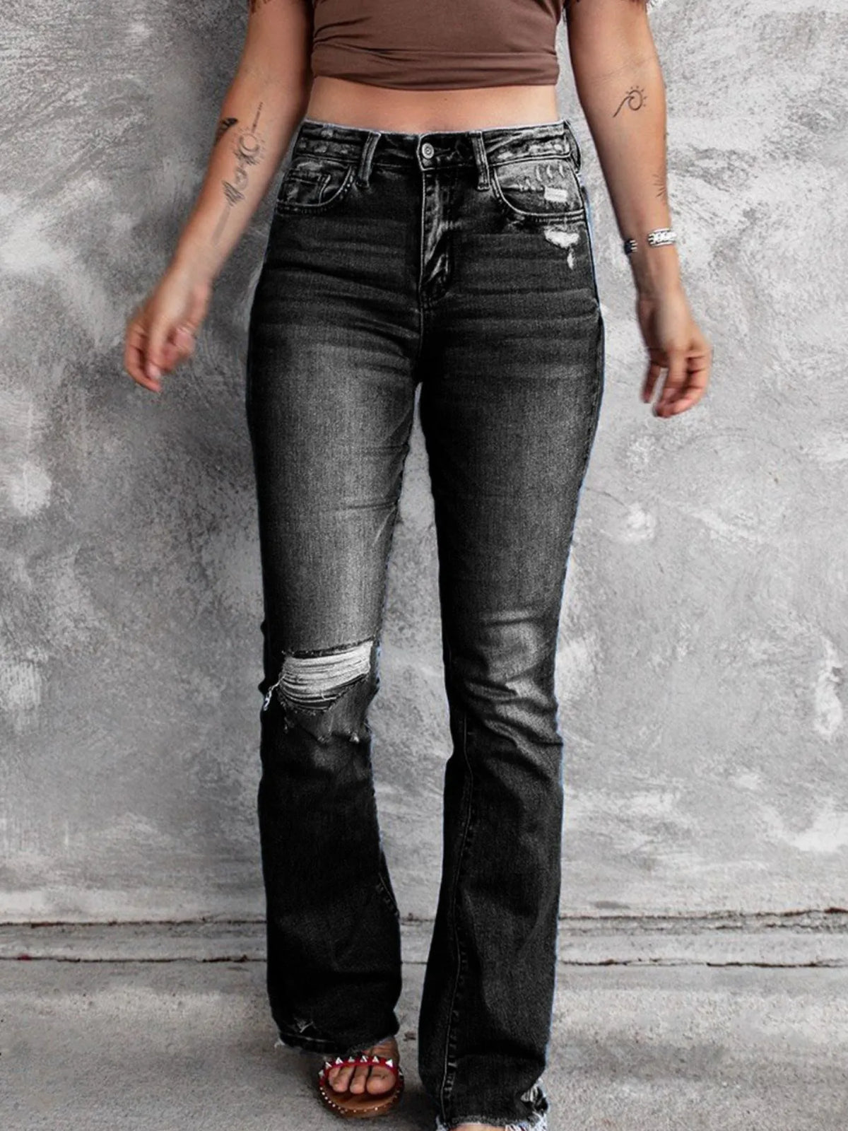 Distressed flare denim jeans by Plush Fashion Hub with ripped details and a high-waist fit, styled on a model.