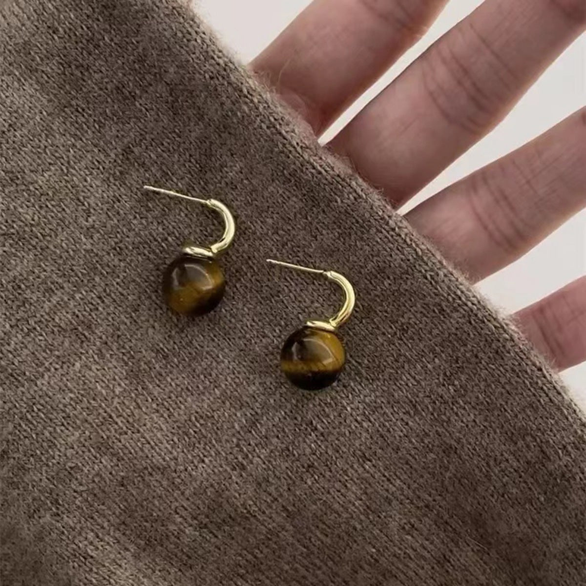 Gold tiger eye ball drop earrings from Plush Fashion Hub featuring smooth, polished gemstone spheres with elegant dangle design.