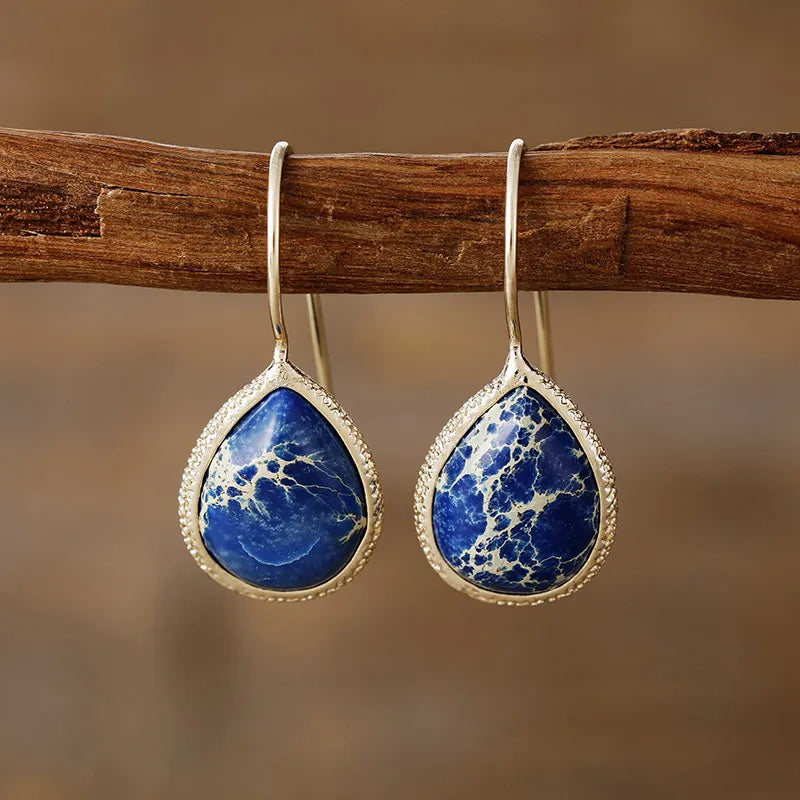 Copper natural stone teardrop earrings with gold accents, showcasing elegant jewelry design on a white background.