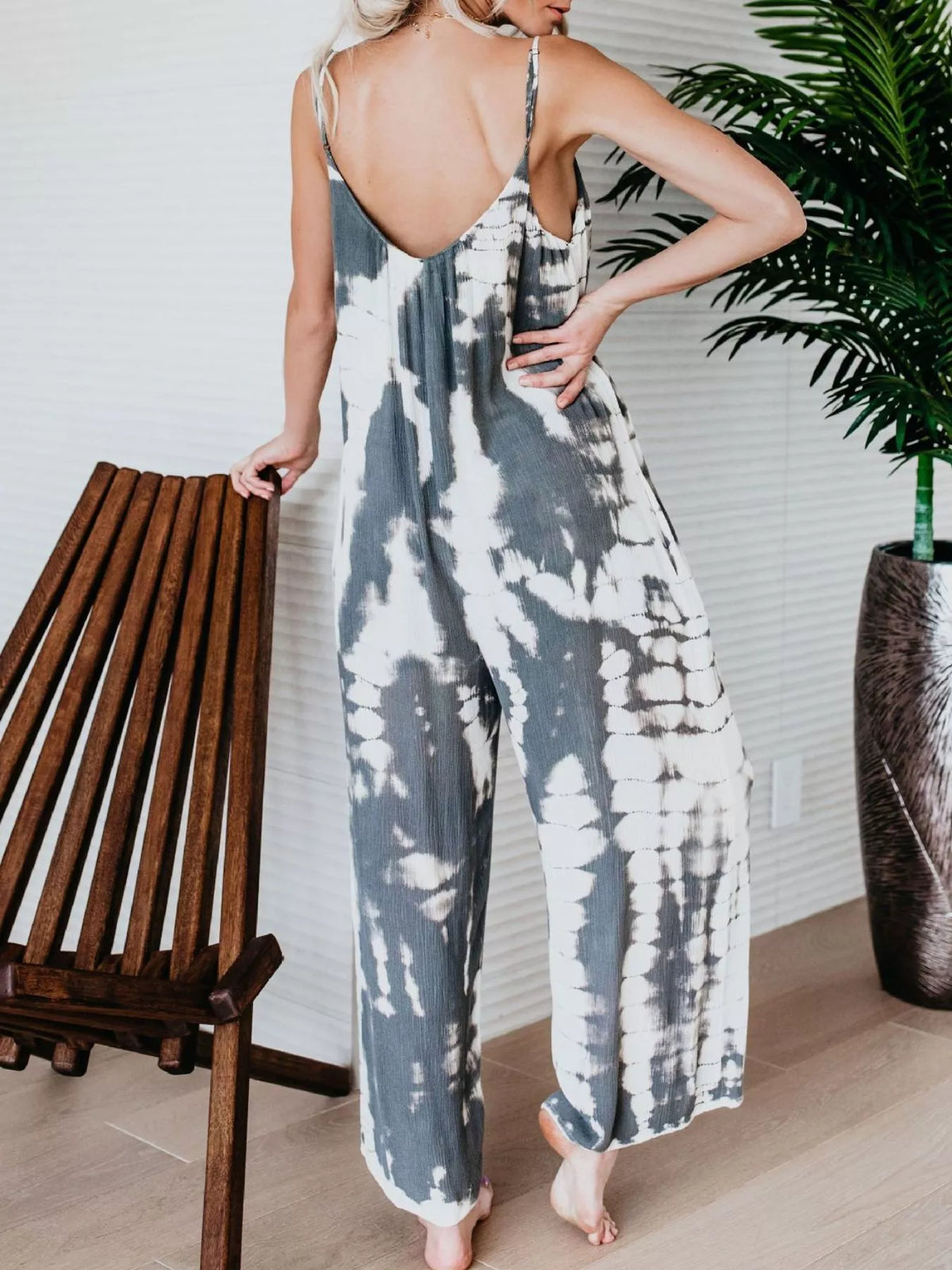 Plus size tie-dye wide-leg jumpsuit by Plush Fashion Hub, featuring vibrant colors and a relaxed fit on a model.