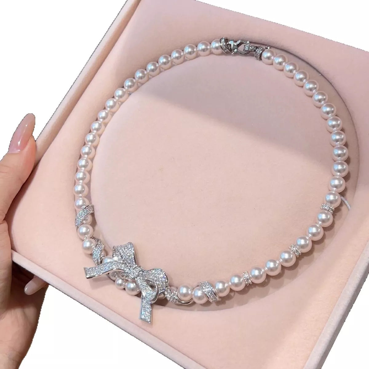 Elegant pearl necklace with a bow pendant, crafted by Plush Fashion Hub, featuring a classic and stylish jewelry design.
