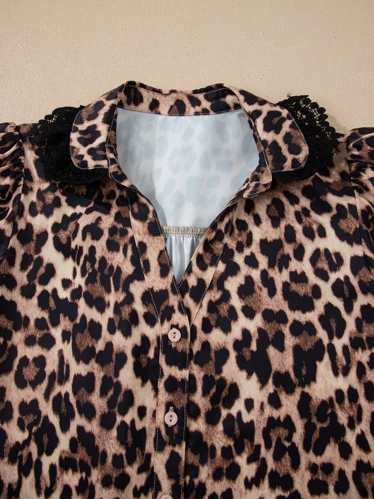 Leopard print short sleeve blouse with lace trim and button-front from Plush Fashion Hub, displayed on a hanger.