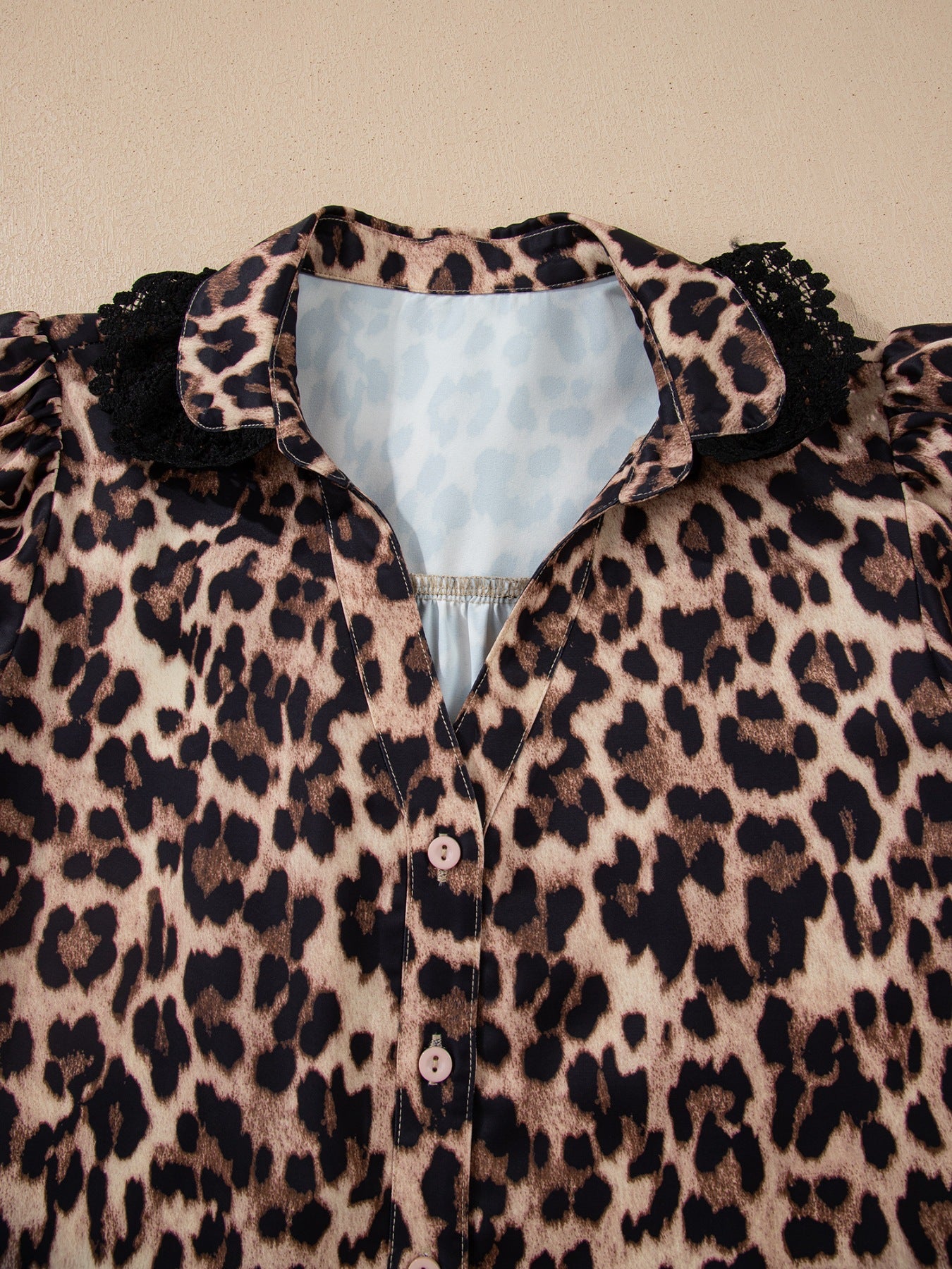 Leopard print short sleeve blouse with lace trim and button front, trendy women's top by Trendsi featuring bold animal print design.