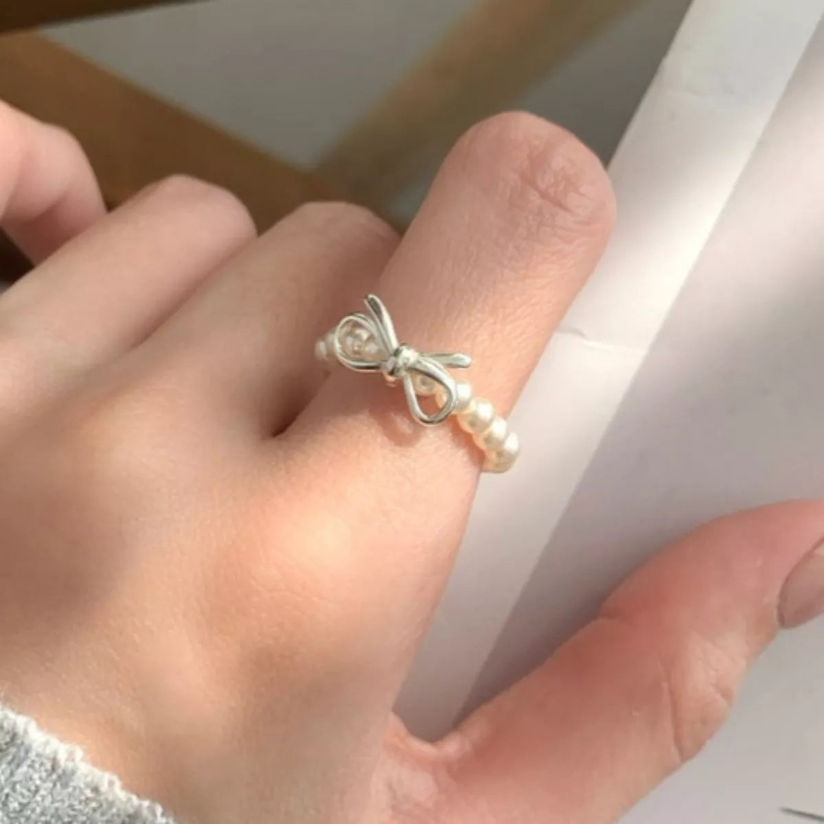 Plush Fashion Hub bow pearl beaded ring with elegant design, featuring a bow and pearl accents on a silver band.