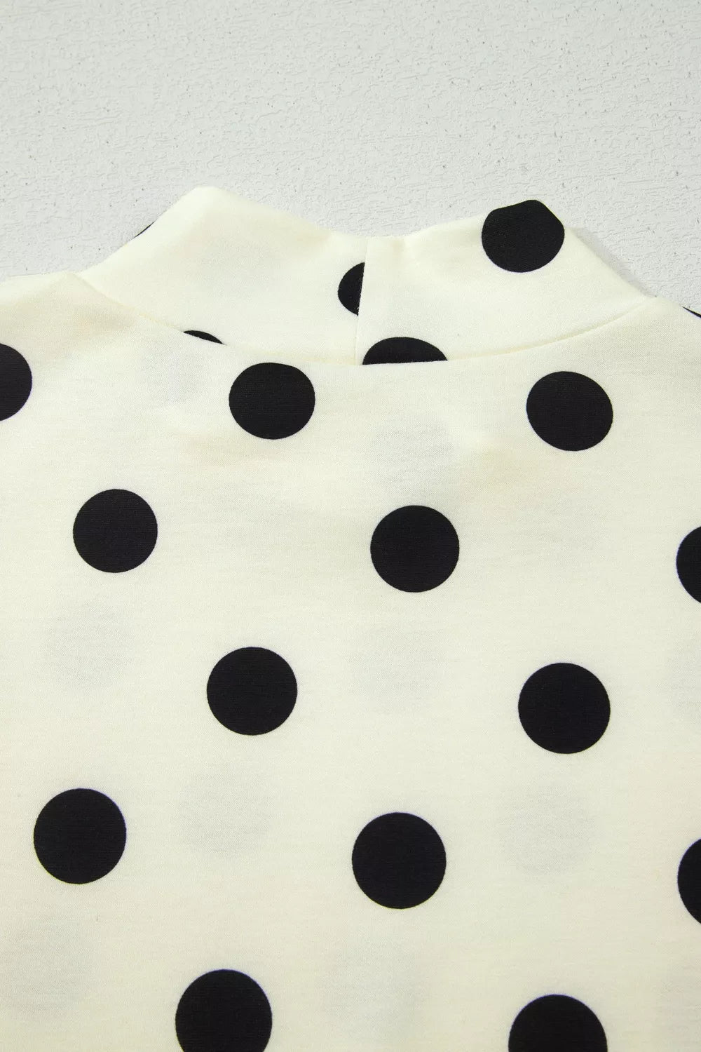 Polka dot print high neck dolman top in black and white, trendy women's tops with relaxed fit and long sleeves.