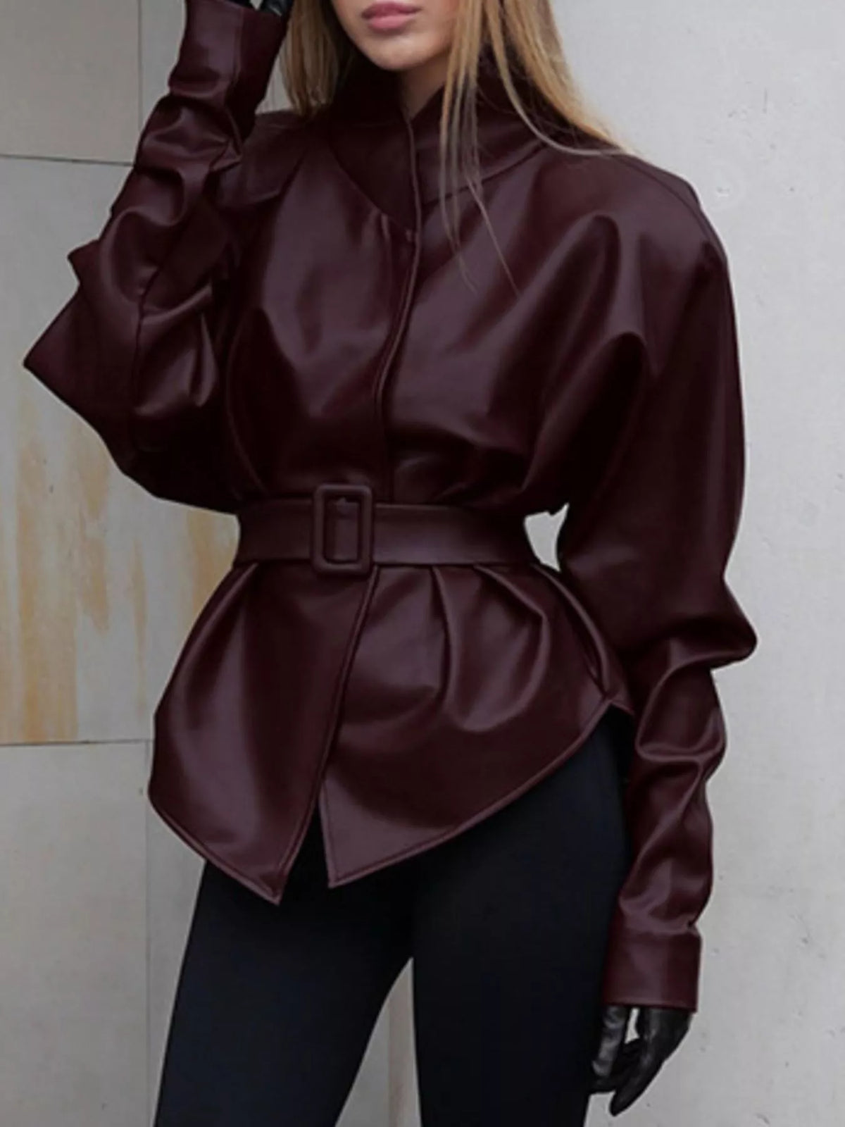 Women's faux leather jacket with stand collar and belted design by Trendsi, featuring a sleek, stylish look and tailored fit.